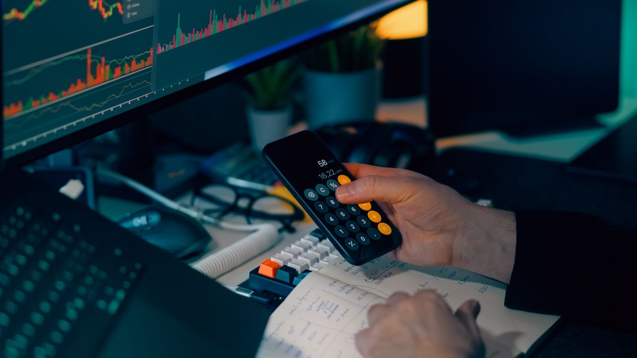About Business analysis with calculator and computer monitor displaying financial graphs and charts.